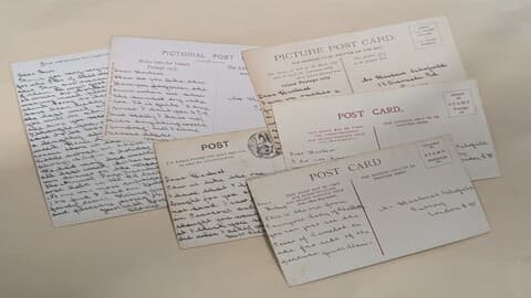 Sepia photo of a selection of letters and postcards, with handwritten text, from the Schofield collection